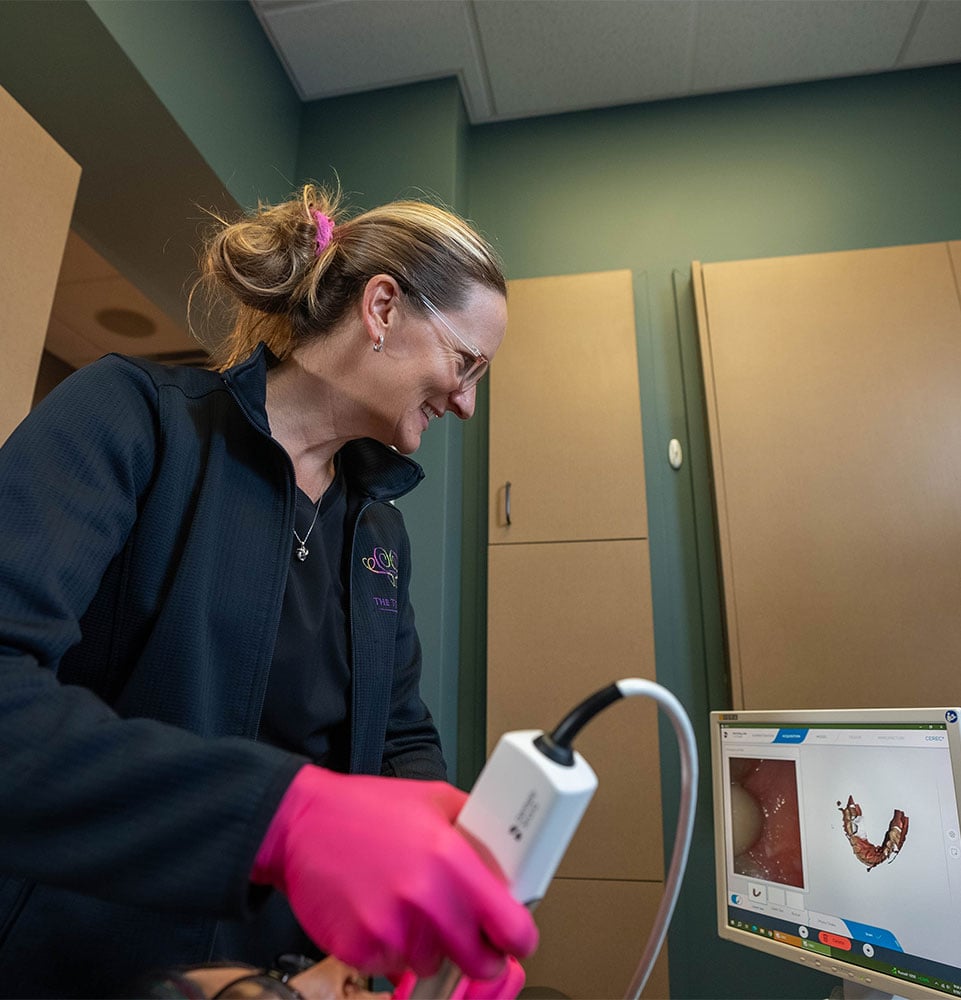 staff member examining patient within the dental practice