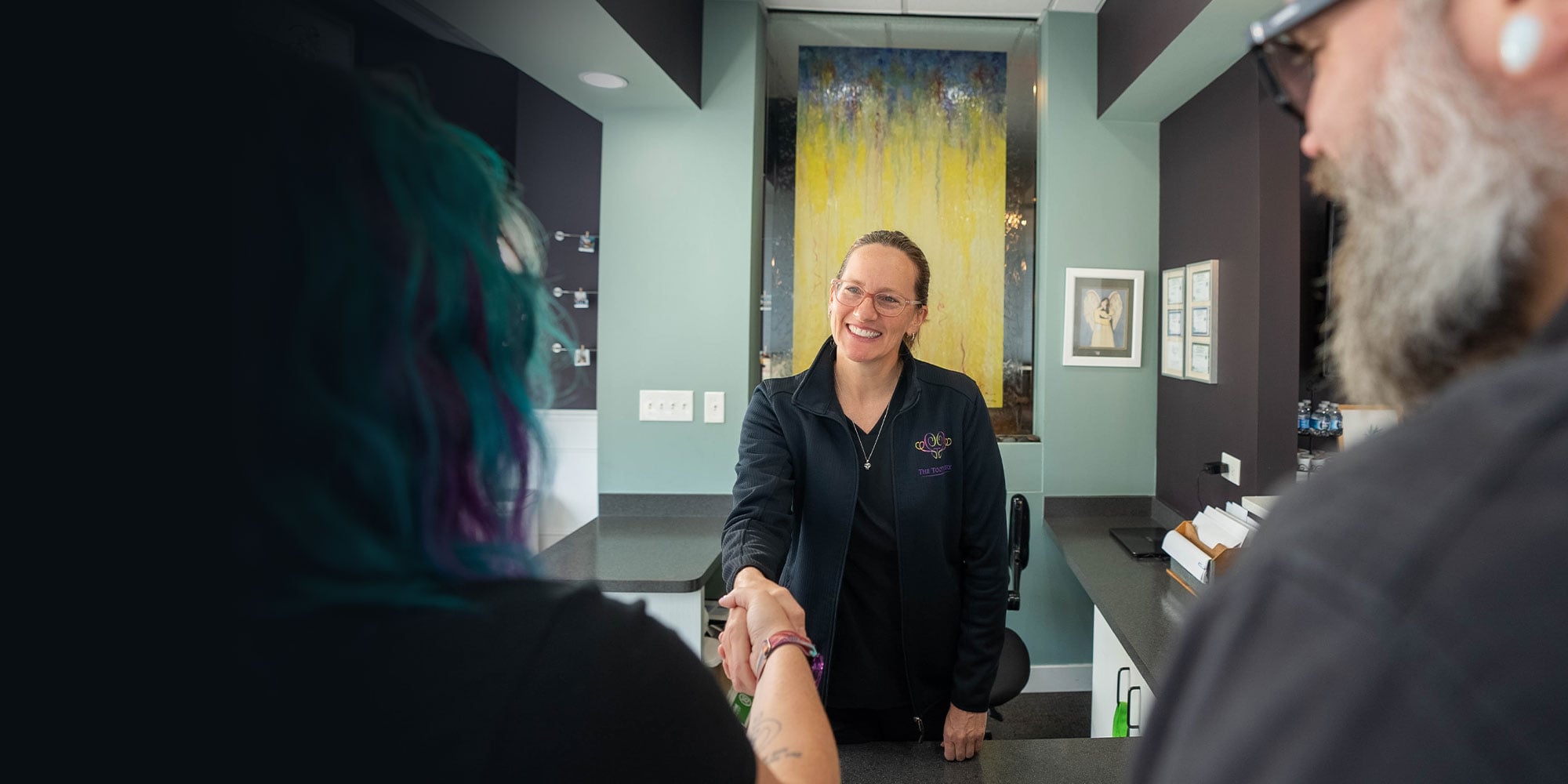 A Toothery team member welcoming a patient at the front desk